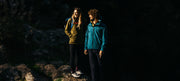 Pair standing on a rock with mountainous background