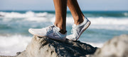 Vivo Barefoot Primus Lite III being worn standing on a rock in front of the sea